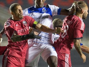 Fury defender Rafael Alves, left, and Edmonton Pape Diakité go for the ball with Fury player James Bailey in close in the second half at TD Place stadium. (WAYNE CUDDINGTON)