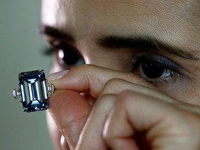 A Christie's employee poses with the 14.62 carats Oppenheimer Blue diamond during a preview in Geneva, Switzerland May 12, 2016. REUTERS/Denis Balibouse/File Photo