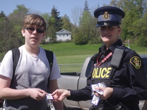 Const. Lisa Narancsik hands out chocolate Kisses to student Justin Barefoot during a pop out Keep it Safe and Sober campaign at IDCI on May 19. HEATHER RIVERS/WOODSTOCK SENTINEL-REVIEW
