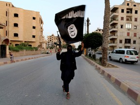 A member loyal to Islamic State waves a flag in Raqqa, on June 29, 2014. (REUTERS/Stringer/File Photo)