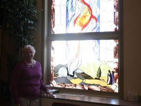 Shannon Taylor stands by one of the six stained glass windows she created, one that represents the resurrection of Jesus Christ. Taylor spent more than two years working on the windows, an experience that meant a lot to her on a personal level. Alex Boates/Postmedia