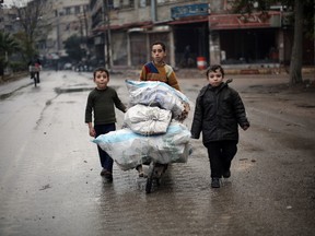 Supplied Photo
In this Nov. 17, 2015, photo provided by Save the Children, three children push a cart of firewood down a street in Eastern Ghouta, Syria. A report published Tuesday, March 8, 2016, by Save the Children, paints a grim picture in Syria’s besieged cities, where young people have lost any hope for the future, living in constant fear of aerial bombardment and lacking access to food and proper medical care.