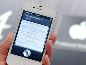 A woman displays Siri, voice-activated assistant technology, on an Apple iPhone 4S in Taipei on July  30, 2012.  (AFP PHOTO/Mandy Cheng)