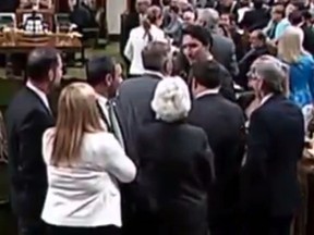 Prime Minister Justin Trudeau goes across the floor in the House of Commons and comes in contact with another MP, shown in this video frame grab.