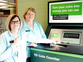Sharon Grainger, front, and Francine Waekens check out a new coin changer that was installed at the TD Canada Trust branch on St. Clair Street in Chatham, Ont., on Tuesday, April 2, 2013. (BOB BOUGHNER/THE CHATHAM DAILY NEWS/Postmedia Network)