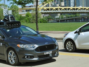 In this undated photo provided by Uber, a Ford Fusion hybrid outfitted with radars, laser scanners and high-resolution cameras drives along the streets of Pittsburgh. Ride-hailing company Uber Technologies Inc. is testing the self-driving car on public streets in the city. San Francisco-based Uber says Pittsburgh is an ideal place to test self-driving cars because it has a wide variety of weather and road types. (Uber via AP)