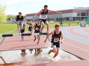 Athletes compete in the boys 2,000 metre steeplechase event at the local high school track and field championships at the track at Laurentian University in Sudbury, Ont. on Thursday May 19, 2016. John Lappa/Sudbury Star/Postmedia Network