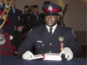 Const. Christian Nungisa receives his wallet badges at a 2013 ceremony. (Chris Mikula/Postmedia)