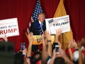 Supporters wave signs as Republican presidential candidate Donald Trump speaks at a campaign event Thursday, May 19, 2016 in Lawrenceville, N.J. (AP Photo/Mel Evans)