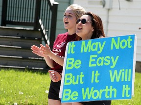 Wallaceburg District Secondary School students Abbi O'Brien, left, and Hailey Dumais, cheer on participants in the school's annual Tinman Triathlon on May 19. The event involved 261 participants, with 91 entries, 31 individual entries and 60 teams.