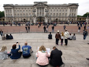 Tourists around Buckingham Palace in London, Thursday, May 19, 2016. British police say they have arrested a man who scaled a wall and got into the grounds of Buckingham Palace. The Metropolitan Police force says a 41-year-old man was detained in the palace grounds Wednesday evening on suspicion of trespassing on a protected site. (AP Photo/Kirsty Wigglesworth)