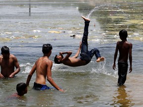 Indian children play in the Sabarmati river to beat the heat on a hot summer day in Ahmadabad, India, Friday, May 20, 2016. The prolonged heat wave this year has already killed hundreds and destroyed crops in more than 13 states, impacting hundreds of millions of Indians. (AP Photo/Ajit Solanki)