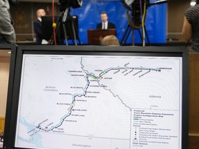 A map of the Kinder Morgan Trans Mountain pipeline is seen in the foreground as Dr. Robert Steedman, Chief Environment Officer of the National Energy Board, centre, releases their report on the Trans Mountain pipeline expansion project are seen in Calgary, Thursday, May 19, 2016.THE CANADIAN PRESS/Jeff McIntosh