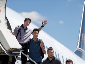 London Knights forwards Mitch Marner and Cliff Pu wave while Owen MacDonald looks on as they board a flight on Wednesday to Red Deer, Alberta, where they will compete in the Memorial Cup. (Craig Glover/The London Free Press)