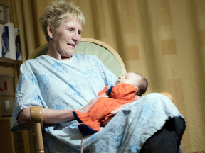 Mary Grainger, a volunteer at the Children's Hospital of Eastern Ontario, cuddles Jackson Blonde in the neonatal intensive care unit Friday, May 20, 2016. Grainger has cuddled thousands of infants over her 40 years at the hospital.  (Darren Brown/Postmedia)