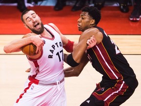 Toronto Raptors centre Jonas Valanciunas (17) runs into Miami Heat centre Hassan Whiteside (21) during NBA playoff action in Toronto on Thursday, May 5, 2016. (THE CANADIAN PRESS/Nathan Denette)