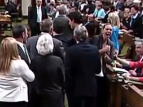 Prime Minister Justin Trudeau goes across the floor in the House of Commons and comes in contact with MP Ruth-Ellen Broussea, right, shown in this video frame grab from May 18, 2016.
