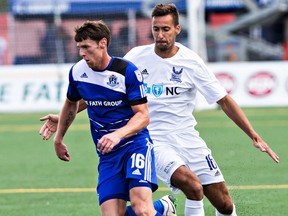 Edmonton's Daryl Fordyce is pursued by Carolina's Dzenan Catic during FC Edmonton's NASL soccer game against the Carolina Railhawks at Clarke Field in Edmonton, Alta. on Sunday, Aug. 16, 2015.