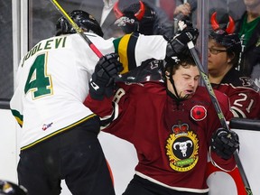 London Knights defenceman Olli Juolevi slams Adam Helewka of the host Rebels into the boards during the first period of the opening game of the Memorial Cup in Red Deer, Alta., on Friday night. (The Canadian Press)