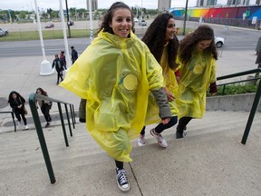 Wearing lemon-themed rain ponchos, Beyonce fans Teagan Harris, Jasvine Kular and Moira Percival head into The Formation World Tour stop at Commonwealth Stadium in Edmonton on Friday May 20, 2016.