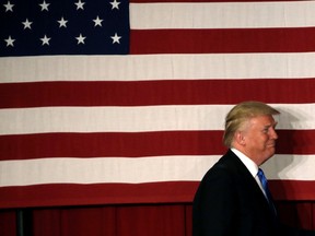 U.S. Republican presidential candidate Donald walks to the stage past an American flag at a fundraising event where he appeared with New Jersey Governor Chris Christie in Lawrenceville, New Jersey, U.S., May 19, 2016. REUTERS/Mike Segar