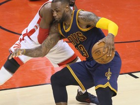 LeBron James tries to get past DeMarre Carroll in Game 3 action on Saturday night. (Veronica Henri/Toronto Sun)