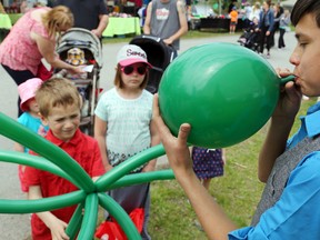 Local magician Ivan Demine inflates the head of a balloon octopus for Toronto's Josh Chamberlain, 6, Saturday at Frankford Riverfest. Demine's  creations kept him in demand with the younger crowd.