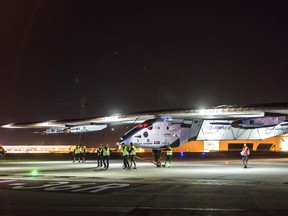 In this photo provided by Solar Impulse, a crew attends to the "Solar Impulse 2," after the plane landed at at Tulsa International Airport on May 12, 2016 in Tulsa, Oka. The Swiss-made Solar Impulse 2  landed in Ohio on Saturday night on the latest leg of its historic world tour. (Jean Revillard/Solar Impulse via AP)