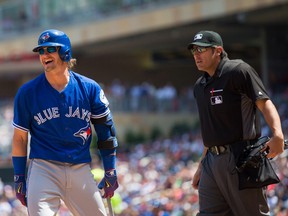 Toronto Blue Jays third baseman Josh Donaldson laughs at home plate umpire Mark Ripperger after a pitch was thrown behind him in the fifth inning against the Minnesota Twins at Target Field. (Brad Rempel-USA TODAY Sports)