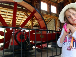 Fyre Larabee, 6, of Wellington cocks her folded umbrella over her shoulder while standing near the steam engine Sunday at Ameliasburgh Heritage Village. See more photos in the print editions of Tuesday's Intelligencer and Thursday's County Weekly News.