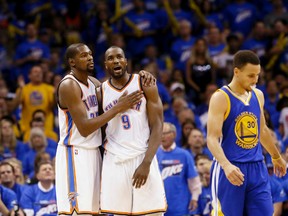 Oklahoma City Thunder forward Kevin Durant and forward Serge Ibaka embrace as Golden State Warriors guard Stephen Curry walks away during the second half in Game 3 of the NBA basketball Western Conference finals  in Oklahoma City, Sunday, May 22, 2016. (AP Photo/Sue Ogrocki)