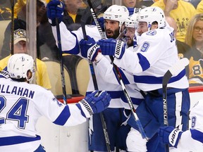 Tampa Bay Lightning's Tyler Johnson, right, jumps on teammates Jason Garrison, center-left, and Nikita Kucherov center-right, as Ryan Callahan joins the celebration after Johnson scored the game winning goal in overtime of Game 5 of the NHL hockey Stanley Cup Eastern Conference finals, Sunday, May 22, 2016, in Pittsburgh. The Lightning won 4-3 in overtime. (AP Photo/Gene J. Puskar)