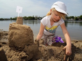 Harmony Prisque, 7, of Belleville builds the foundation of her sand castle along the bank of the Trent River Saturday at Frankford Riverfest. The sand castle competition was one of several new attractions.