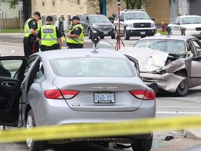 Members of the Winnipeg Police Service work at the scene of a two-car collision at Redwood Avenue and McPhillips Street on Monday, May 23, 2016. Manitoba's Independent Investigation Unit is probing the crash that sent six people to hospital less than a minute after police began pursuing one of the vehicles. (Brian Donogh/Winnipeg Sun/Postmedia Network)