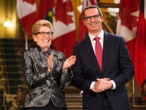 Former Ontario premier Dalton McGuinty laughs with Premier Kathleen Wynne before McGuinty's official portrait is unveiled at Queen's Park in Toronto February 23, 2016. (THE CANADIAN PRESS/Mark Blinch)