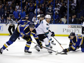 St. Louis Blues defenseman Jay Bouwmeester (19) hits the puck against San Jose Sharks centre Joe Pavelski (8) as the Blues left wing Alexander Steen (20) defends during the third period in Game 1 of the NHL hockey Stanley Cup Western Conference finals, Sunday, May 15, 2016, in St. Louis. (AP Photo/Jeff Roberson)