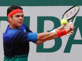 Milos Raonic returns the ball in his first round match at the French Open against Serbia's Janko Tipsarevic at Roland Garros stadium in Paris on Monday, May 23, 2016. (Alastair Grant/AP Photo)