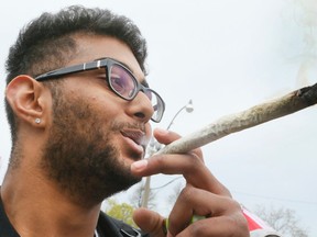 A man smokes a joint during the Global Marijuana March and gathering of pot smokers at Queen's Park in Toronto in this Saturday May 7, 2016 file photo. (Veronica Henri/Toronto Sun/Postmedia Network)