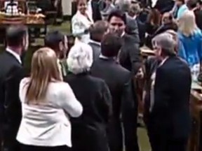 Prime Minister Justin Trudeau goes across the floor in the House of Commons and comes in contact with another MP, shown in this video frame grab on May 18, 2016.
