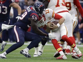 Chiefs quarterback Alex Smith (11) is hit by Texans outside linebacker Whitney Mercilus (59) during first half NFL wild-card action in Houston on Jan. 9, 2016. (Tony Gutierrez/AP Photo)