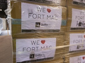 "We heart Fort Mac" signs are visible on donations at the Edmonton Emergency Relief Services Society (EERSS) Donation Warehouse.