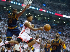 Raptors guard Kyle Lowry (centre) makes a pass under the basket in front of Cavaliers centre Tristan Thompson (left) and LeBron James (right) during first half action in Game 4 of the Eastern Conference final in Toronto on Monday, May 23, 2016. (Ernest Doroszuk/Toronto Sun)