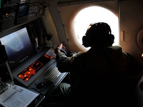 U.S. Navy LT. JG Dylon Porlas looks out the window of a U.S. Navy Lockheed P-3C Orion patrol aircraft from Sigonella, Sicily, Sunday, May 22, 2016, searching the area in the Mediterranean Sea where the EgyptAir Flight 804 en route from Paris to Cairo went missing on May 19. (AP Photo/Salvatore Cavalli)