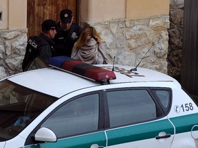 Police officers escort a Slovakian model Mayka Marica Kukucova (R) from court in Trencin, April 10, 2014. Kukucova was arrested on Tuesday in the village of Nova Bosaca, Slovakia following the death of British millionaire Andrew Bush. Bush was found shot dead early on Saturday at his property near Estepona, Spain. Kukucova is the prime suspect in the case and went to police voluntarily, according to reports. She was arrested on suspicion of consumed intentional homicide and is expected to be extradited to Spain. REUTERS/Radovan Stoklasa