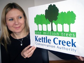 Luiza Moczarski, Kettle Creek Conservation Authority public relations supervisor, looks over new logo commemorating the agency's planting its millionth tree in 2013.