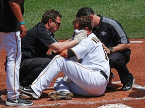 Pirates pitcher Ryan Vogelsong (centre) is helped by team trainers after being hit in the head by a pitch from Rockies starting pitcher Jordan Lyles during second inning MLB action in Pittsburgh on Monday, May 23, 2016. (Gene J. Puskar/AP Photo)