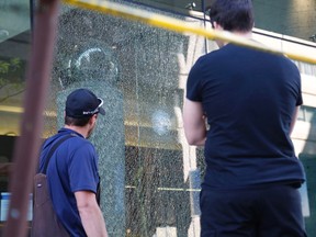 Workers examine shattered glass at the seen of a shooting at the EDC building at O'Connor and Slater on Monday, May 23, 2016.  Patrick Doyle/Postmedia