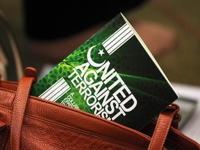 A handbook entitled "United Against Terrorism" sticks out of a woman's purse at the Winnipeg Central Mosque in Winnipeg, September 29, 2014. (Brian Donogh/Winnipeg Sun/Postmedia Network)