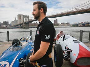 Race car driver James Hinchcliffe, of Canada, stands next to iconic Indy cars during an interview, Tuesday, May 24, 2016, in New York. (AP Photo/Bebeto Matthews)