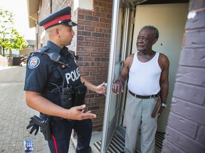 Toronto Police Const. Ryan Willner talks with Arthur Duvernais as he talks with residents along Jamestown Cres. in Toronto on Tuesday May 24, 2016. (Ernest Doroszuk/Toronto Sun)